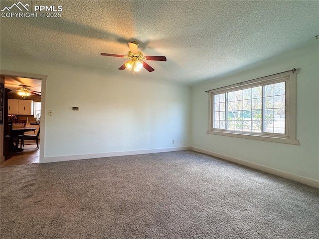 carpeted spare room featuring baseboards, a ceiling fan, and a textured ceiling