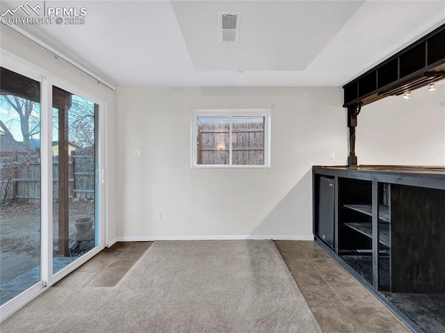 spare room with baseboards and visible vents
