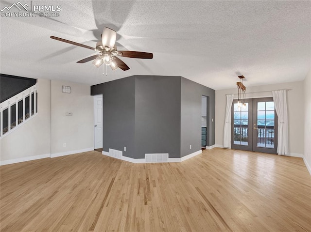 unfurnished living room featuring a textured ceiling, light wood-type flooring, ceiling fan, baseboards, and visible vents
