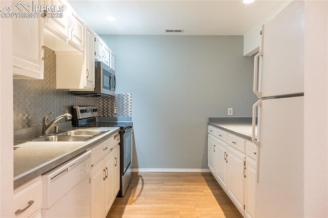 kitchen featuring visible vents, light wood-style floors, a sink, backsplash, and stainless steel appliances