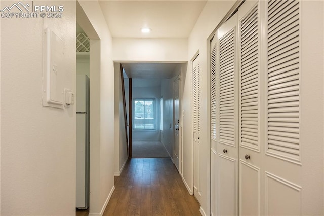 hallway featuring baseboards and dark wood finished floors