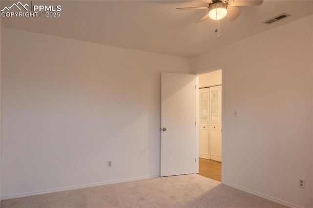 carpeted empty room featuring a ceiling fan, baseboards, and visible vents