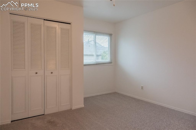 unfurnished bedroom featuring carpet flooring, baseboards, and a closet