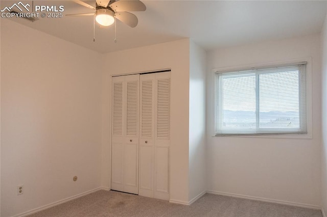 unfurnished bedroom featuring baseboards, light colored carpet, ceiling fan, and a closet