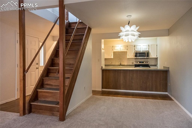 kitchen with appliances with stainless steel finishes, backsplash, and carpet flooring
