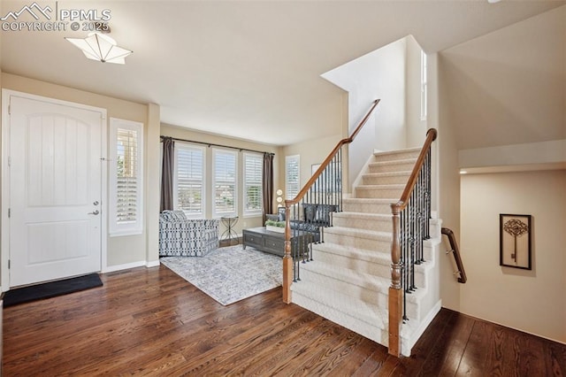 entryway featuring dark wood-style floors, stairway, and baseboards