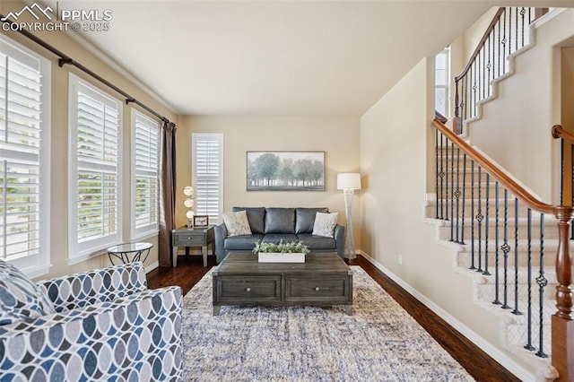 living area with stairs, baseboards, and dark wood-type flooring