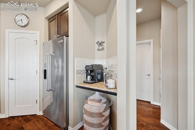 kitchen with dark wood finished floors, tasteful backsplash, high end fridge, and baseboards