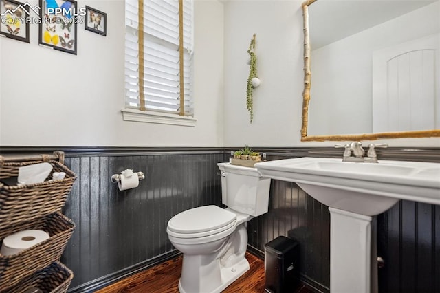 bathroom with toilet, wainscoting, and wood finished floors