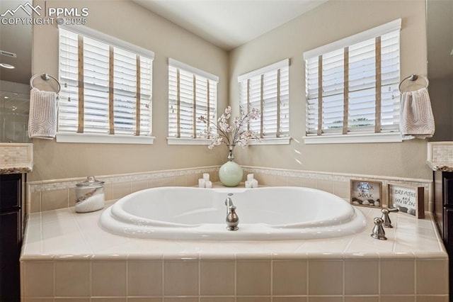bathroom with vanity and a bath