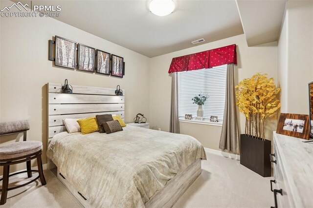 bedroom featuring baseboards, visible vents, and light colored carpet
