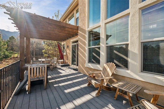 wooden terrace with outdoor dining space and a mountain view