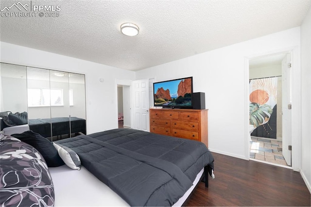 bedroom with baseboards, wood finished floors, a textured ceiling, and a closet