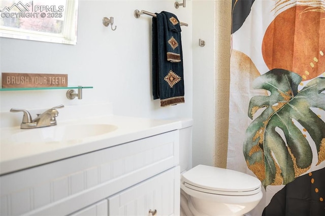 bathroom featuring toilet, curtained shower, and vanity