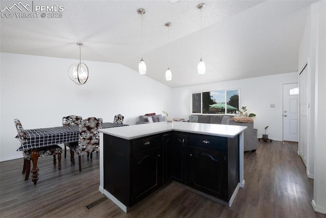 kitchen featuring visible vents, light countertops, dark wood-style floors, and vaulted ceiling