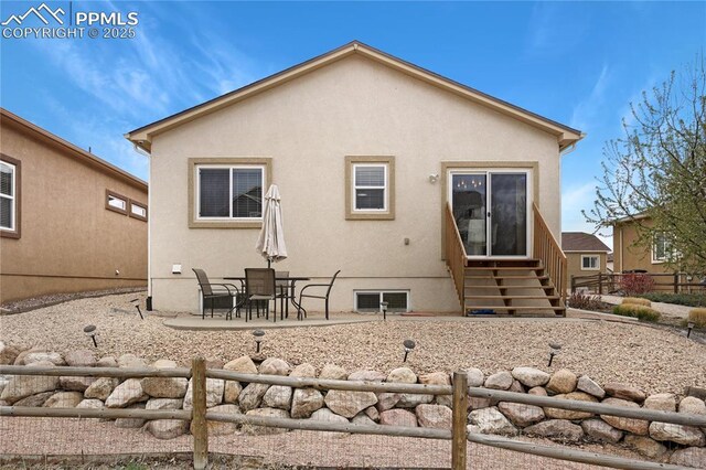 7044 Davey Crocket Ct, Colorado Springs, CO 80922 - rear view of house with fence, stucco siding, entry steps, and a patio area