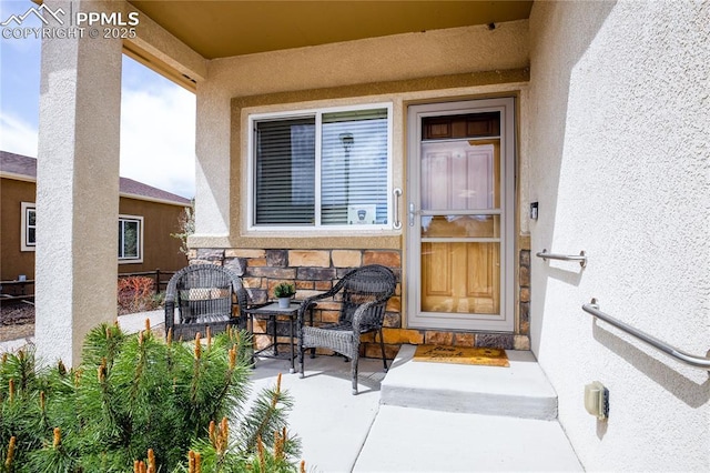 entrance to property featuring stone siding and stucco siding