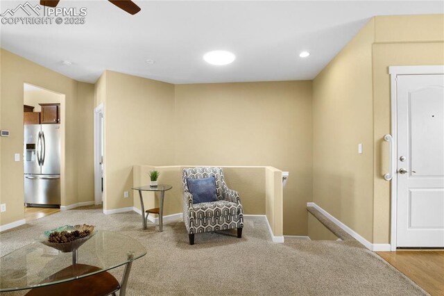 7044 Davey Crocket Ct, Colorado Springs, CO 80922 - living area with baseboards, a ceiling fan, carpet, and an upstairs landing