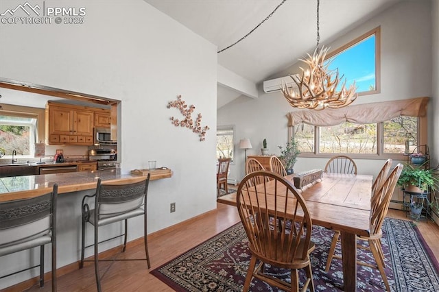 dining area featuring light wood finished floors, an inviting chandelier, an AC wall unit, a baseboard radiator, and high vaulted ceiling