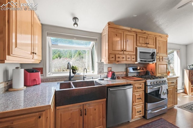 kitchen featuring a wealth of natural light, appliances with stainless steel finishes, tile countertops, and a sink