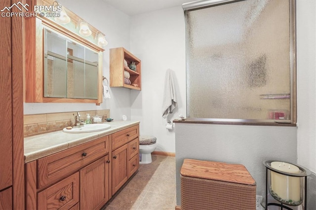 bathroom featuring tile patterned floors, vanity, a shower with door, and toilet
