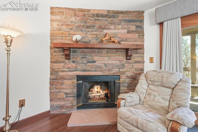 sitting room with baseboards, wood finished floors, and a fireplace
