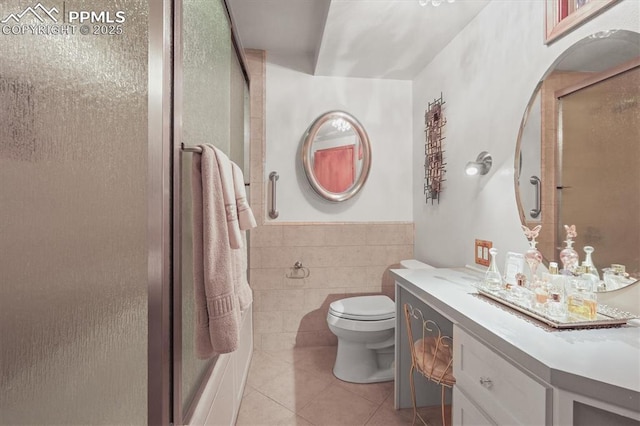 bathroom featuring toilet, tile walls, tile patterned flooring, a shower stall, and vanity