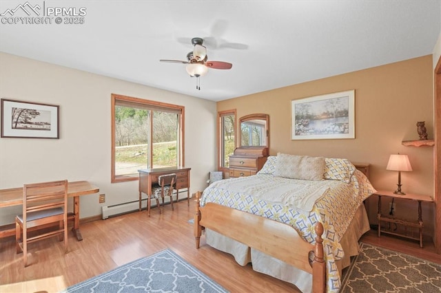 bedroom with a baseboard heating unit, baseboards, wood finished floors, and ceiling fan