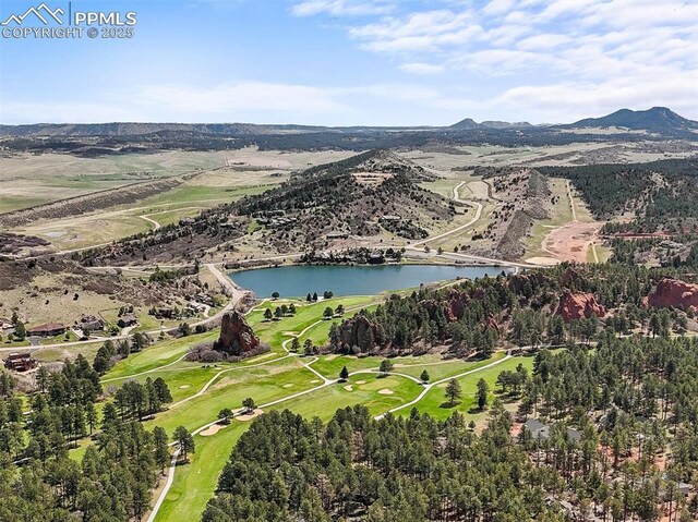 aerial view with golf course view and a water and mountain view