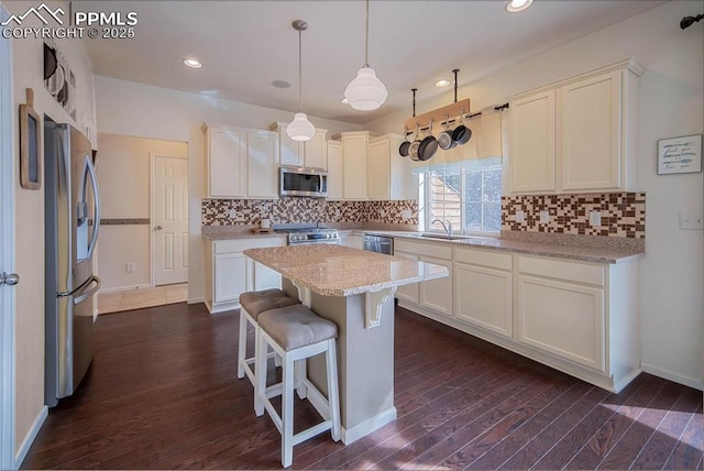kitchen with stainless steel appliances, backsplash, dark wood finished floors, and a center island