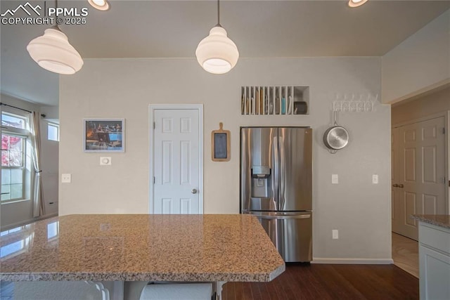 kitchen featuring dark wood finished floors, recessed lighting, light stone counters, baseboards, and stainless steel refrigerator with ice dispenser