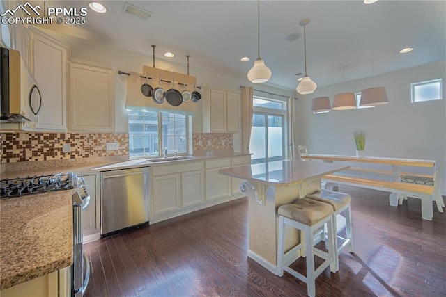 kitchen featuring a sink, decorative backsplash, stainless steel appliances, visible vents, and white cabinets