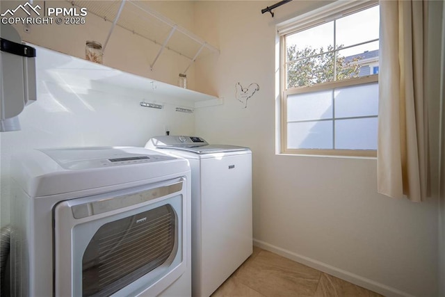 laundry room featuring light tile patterned flooring, independent washer and dryer, laundry area, and baseboards