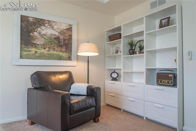 sitting room featuring baseboards, visible vents, and light colored carpet
