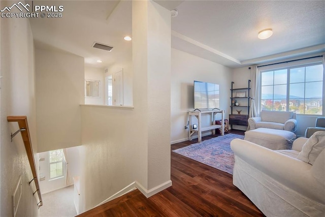 living room with baseboards, visible vents, dark wood finished floors, and recessed lighting