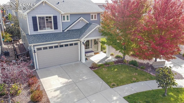 traditional home featuring a front lawn, a shingled roof, a garage, driveway, and central AC