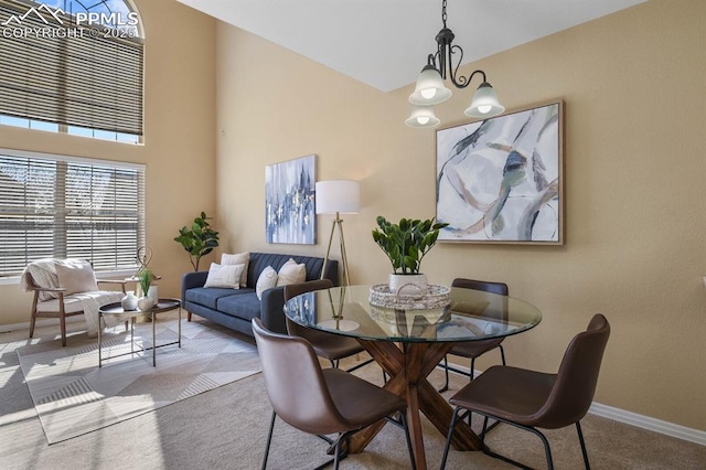 carpeted dining room featuring baseboards and a chandelier