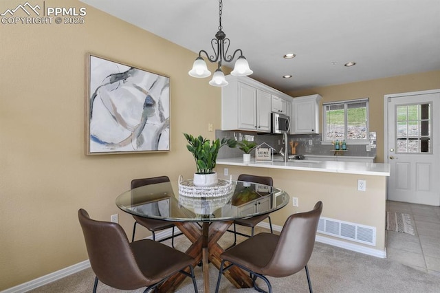 carpeted dining room featuring recessed lighting, tile patterned flooring, baseboards, and an inviting chandelier
