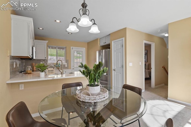 dining space featuring light carpet, baseboards, recessed lighting, and a notable chandelier