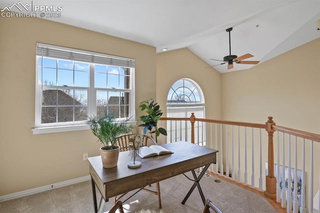 office with lofted ceiling, a ceiling fan, baseboards, and light colored carpet