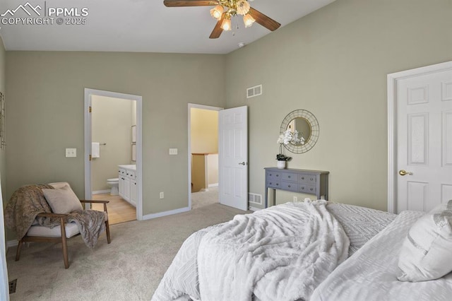 bedroom with visible vents, light carpet, connected bathroom, baseboards, and high vaulted ceiling