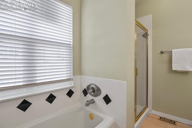 bathroom with a bath and a stall shower