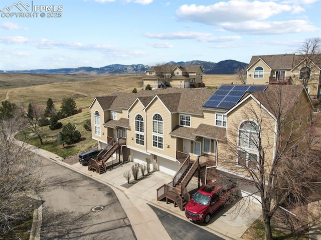 view of front of property with driveway, stairs, a mountain view, and a garage