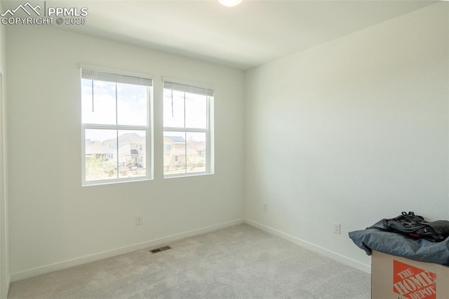 empty room featuring visible vents, baseboards, and light carpet