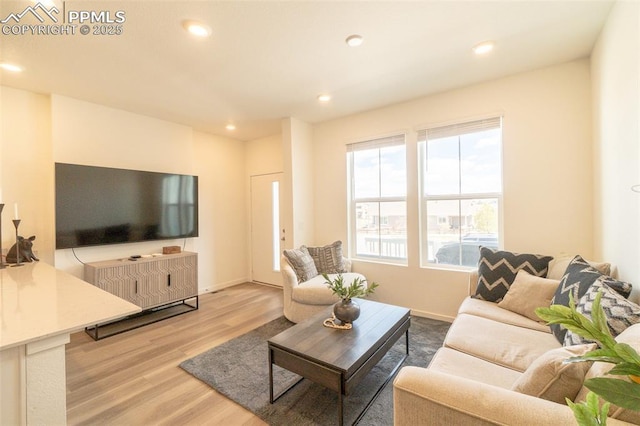 living area featuring baseboards, recessed lighting, and light wood-style floors