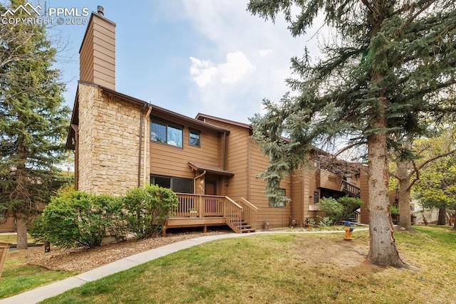 983 Moorings Dr, Colorado Springs, CO 80906 - back of house with a yard, stone siding, a chimney, and a deck