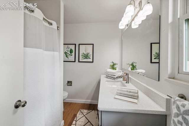 983 Moorings Dr, Colorado Springs, CO 80906 - bathroom featuring wood finished floors, toilet, vanity, a shower with curtain, and baseboards