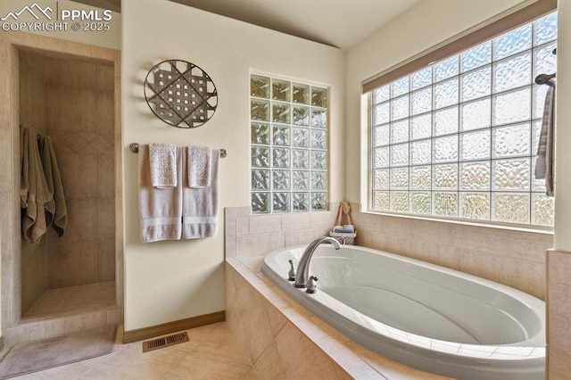 full bathroom featuring a bath, visible vents, a tile shower, tile patterned floors, and baseboards