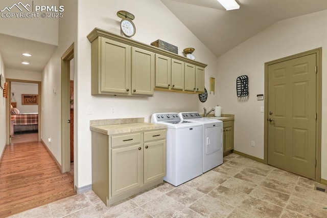 laundry room with a sink, baseboards, cabinet space, and washer and clothes dryer
