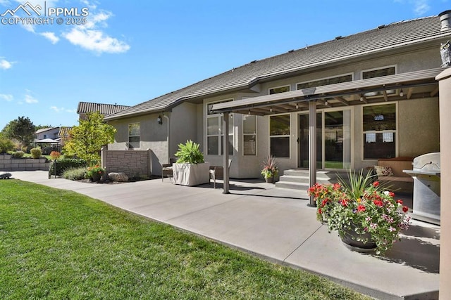back of property featuring a lawn, a tile roof, a patio area, and stucco siding